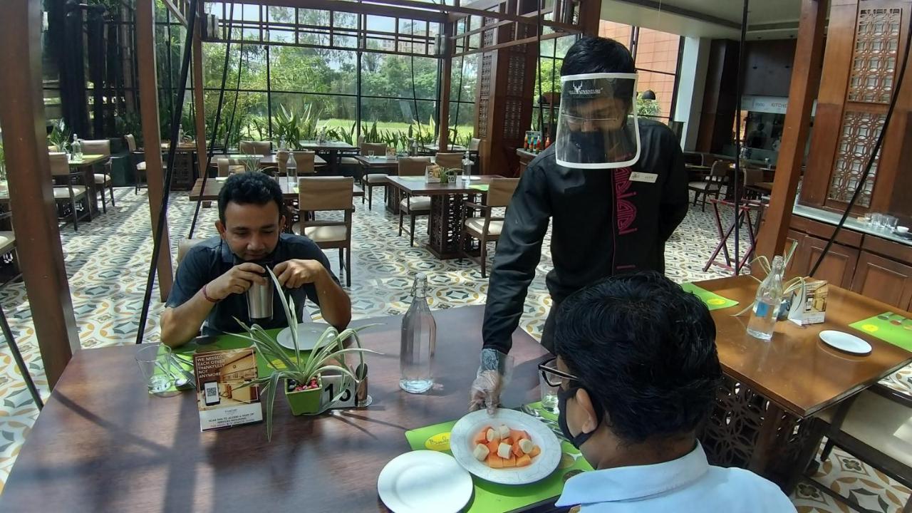 The Orchid Hotel Hinjewadi Pune Exteriör bild A restaurant in India with a waiter wearing a face shield