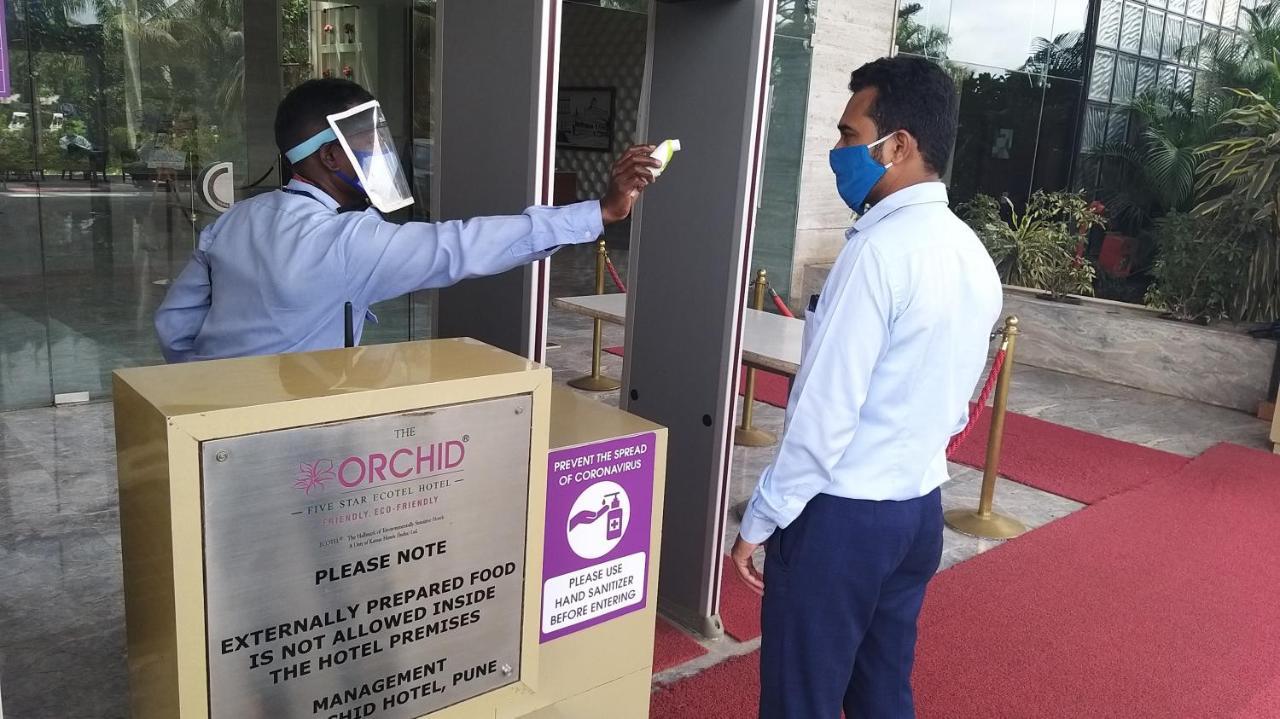 The Orchid Hotel Hinjewadi Pune Exteriör bild Temperature check at the entrance of a hotel in India